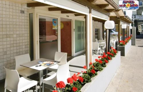 a restaurant with a table and chairs and flowers at Hotel Le Soleil in San Benedetto del Tronto