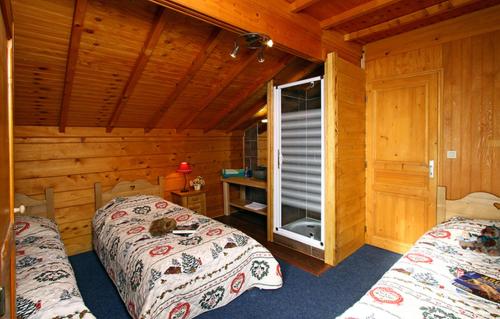 a bedroom with two beds in a log cabin at Odalys Chalet le Soleil Levant in Les Deux Alpes