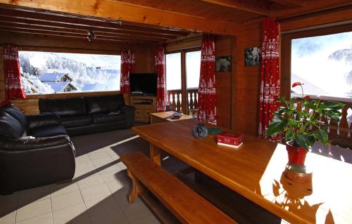 a living room with a couch and a table at Odalys Chalet le Soleil Levant in Les Deux Alpes