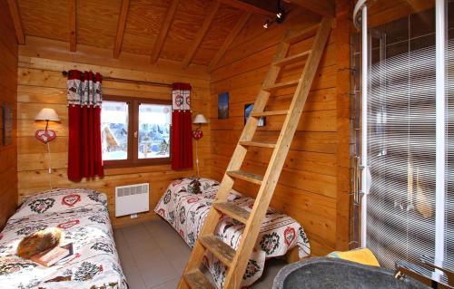 a room with two beds and a ladder in a log cabin at Odalys Chalet le Soleil Levant in Les Deux Alpes