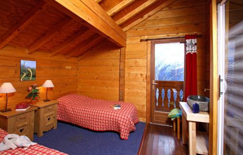 a bedroom with two beds and a window in a cabin at Odalys Chalet le Soleil Levant in Les Deux Alpes