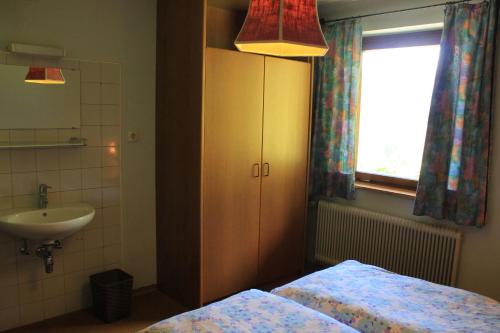 a bathroom with two beds and a sink and a window at Haus Sigrid in Bad Kleinkirchheim