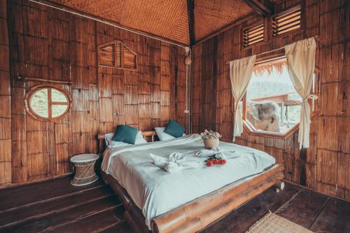 ein Schlafzimmer mit einem Bett in einem Holzzimmer in der Unterkunft Lazy mango homestay in Ban Mae Sapok Nua