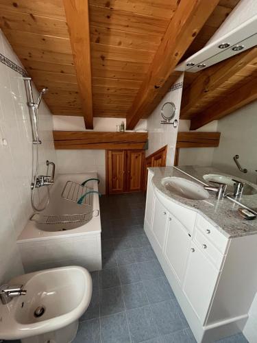 a bathroom with two sinks and a tub and a toilet at L'Atelier du Temps - Chalet Pompon in Cogne
