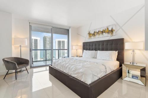 a bedroom with a large bed and a large window at Spacious Luxury Apartment at Beachwalk Resort with Ocean Views and Private Foyer in Hallandale Beach