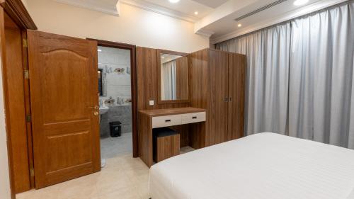 a bedroom with a bed and a sink and a mirror at شقق المتألق الحديثة الفندقية in Dammam