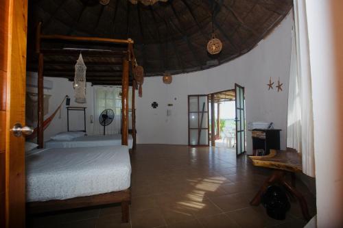 een slaapkamer met 2 bedden en een grote parasol bij Luigi’s Glamping in Bacalar