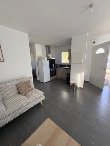 ein Wohnzimmer mit Sofa und eine Küche in der Unterkunft Maison Carredas B in Bouliac