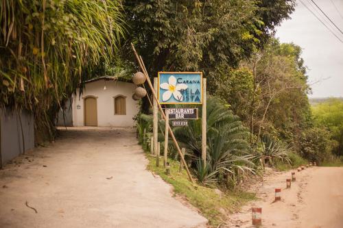 een bord naast een onverharde weg naast een gebouw bij Bela Vista Hotel Boutique in Caraíva