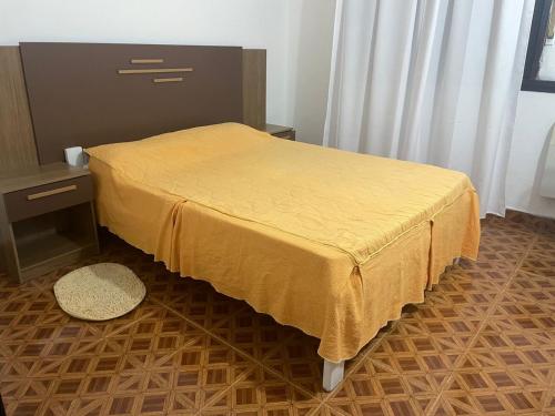 a bedroom with a bed with a yellow bedspread at Maraja318X in Mar de Ajó