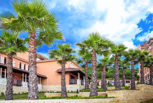 a row of palm trees in front of a building at Villas Elenite Premium in Elenite