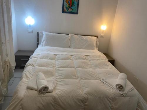 ein weißes Bett mit Handtüchern darauf in einem Schlafzimmer in der Unterkunft Appartamento Premier in Gatteo a Mare
