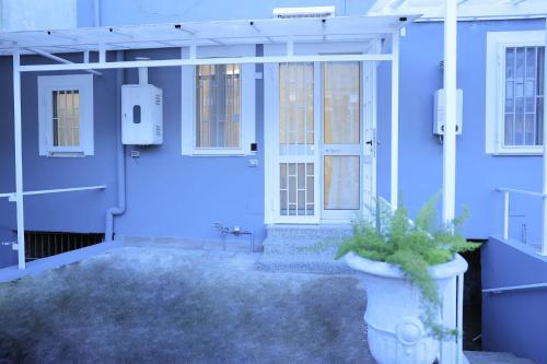 eine blaue Vordertür eines Hauses mit Topfpflanze in der Unterkunft Flora House Pompei Scafati in Scafati