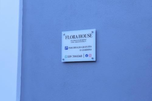 ein Hausschild an einer blauen Wand in der Unterkunft Flora House Pompei Scafati in Scafati