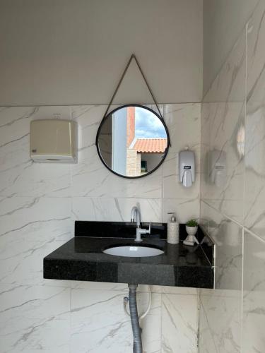 een badkamer met een wastafel en een spiegel bij Recanto Cangaço in Piranhas