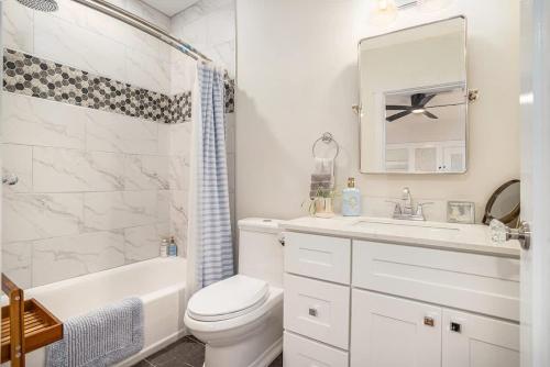a white bathroom with a sink toilet and a mirror at Hemlock Room in Berkeley