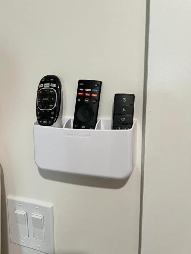 four remote controls in a holder on a refrigerator at Hemlock Room in Berkeley