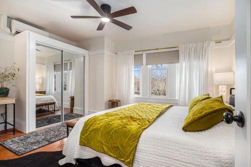 a bedroom with a bed with a yellow comforter and a window at Maple Family Suite in Berkeley