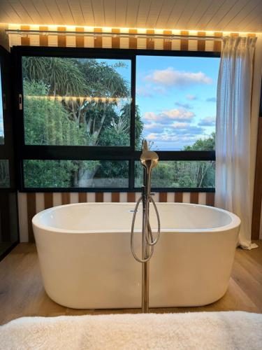 a bath tub in a bathroom with a large window at 007 Loft in Mossel Bay