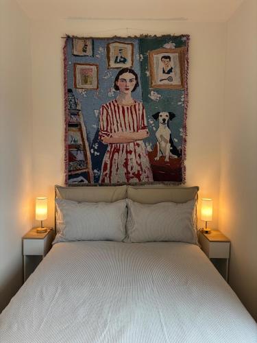 une peinture d'une femme est au-dessus d'un lit dans l'établissement Villa Pieri appartamento rosso, à Fauglia