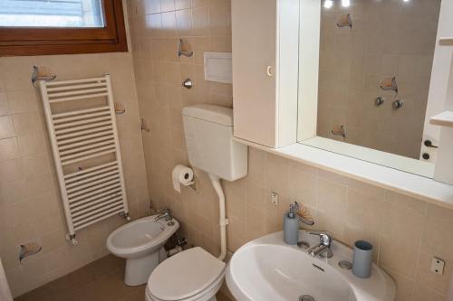 ein kleines Badezimmer mit Toilette und Waschbecken in der Unterkunft Villa Pineta Grande in Lignano Sabbiadoro