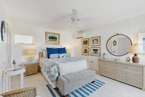 een slaapkamer met een bed, een stoel en een spiegel bij Casa Del Mar in Key Colony Beach