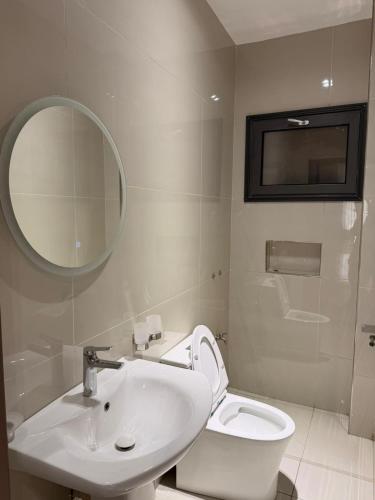 un bagno con lavandino, WC e specchio di Libellule a Dakar