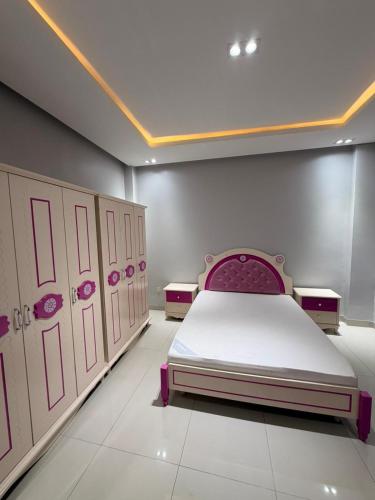 una camera da letto con un letto con mobili rosa e bianchi di Libellule a Dakar