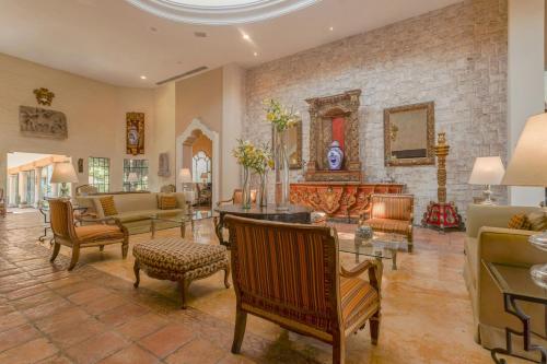 a living room filled with furniture and a stone wall at Casa Mayor Saltillo, Hotel Hacienda in Saltillo