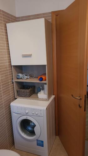 a washer and dryer in a bathroom with a door at MINI House - 3 min dal GRA By followgreenhouserome in Rome
