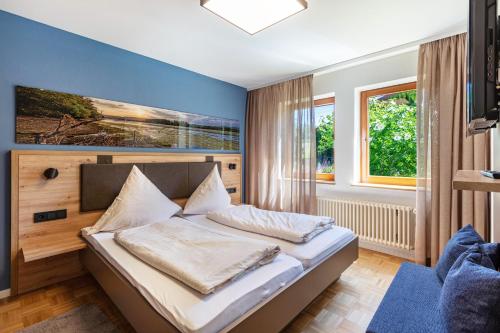 a bedroom with a bed with a blue wall at PAPPELHOF Landurlaub mit Panoramablick - Motorradunterkunft Fahrradunterkunft in Bad Bellingen