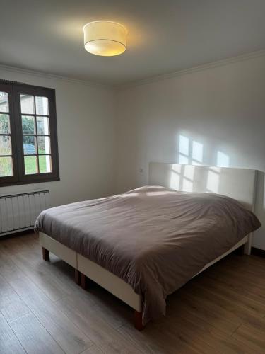 een slaapkamer met een groot bed in een witte kamer bij La Maison Douce in Châtillon-sur-Seine