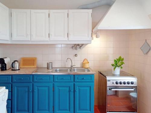 a kitchen with blue cabinets and a sink at Tomar Stunning Views pool cottage in Tomar