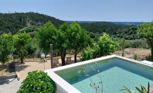 a swimming pool in a yard with trees and mountains at Tomar Stunning Views pool cottage in Tomar