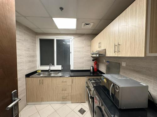 a small kitchen with a sink and a stove at Entire -1 Bedroom Apartment In Oasis Tower in Ajman