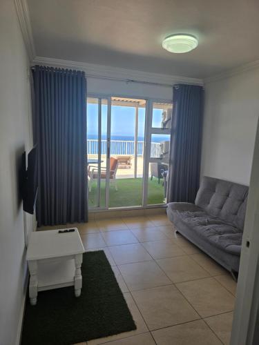 ein Wohnzimmer mit Couch und Blick aufs Meer in der Unterkunft 101 Camarque - 3 Bedroom Apartment In Umdloti - 180 Degree Sea Views in Umdloti