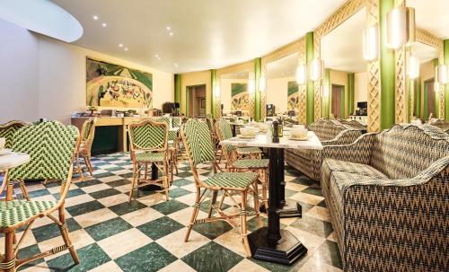 a restaurant with chairs and a table in a room at Hôtel Prince de Conti - Hôtel Rénové in Paris