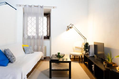 ein Wohnzimmer mit einer weißen Couch und einem Tisch in der Unterkunft Appartamento in Centro Storico a Termini Imerese - Eden Holiday Home in Termini Imerese