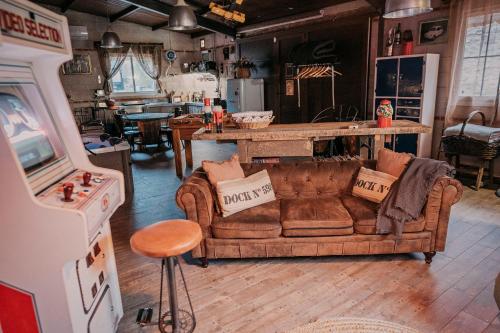 un soggiorno con divano e videogiochi di LARCADE Loft Industrial a Castillo de Bayuela