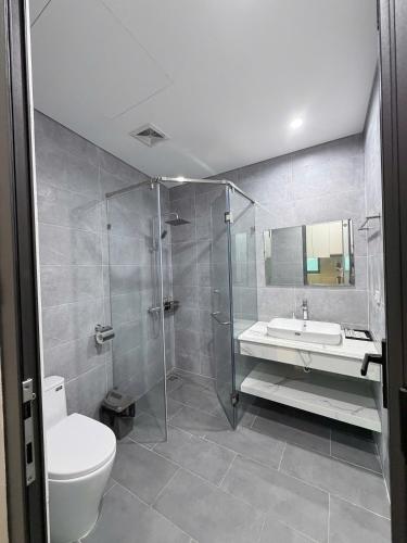 a bathroom with a shower and a toilet and a sink at Hanique Cafe and Stay in Hanoi