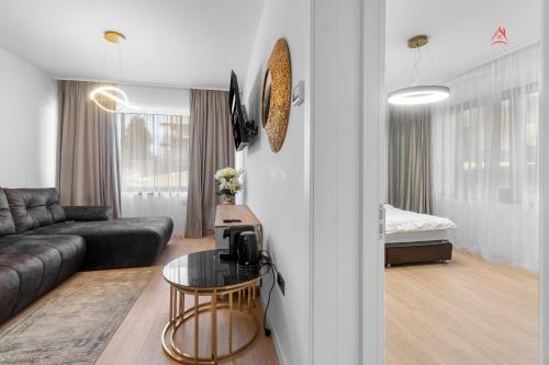 a living room with a couch and a table at Apartament 1 C4 Grand Chalet Poiana Brasov in Braşov
