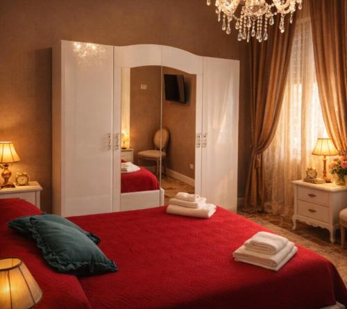 ein Schlafzimmer mit zwei roten Betten und einem Spiegel in der Unterkunft Il Castello Di Venere in Rota d'Imagna