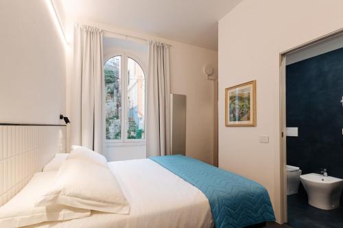 a bedroom with a bed and a toilet and a window at Le camere in città in La Spezia