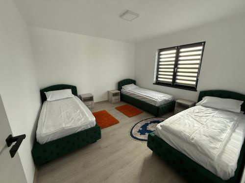 een slaapkamer met twee bedden en een raam bij California Home in Odoreu