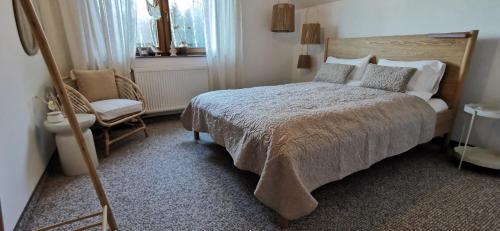 a bedroom with a large bed and a chair at Willa Sowia Dolina in Karpacz