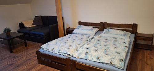Un dormitorio con una cama, un sofá y una silla. en Krčma na statku, en Zásmuky