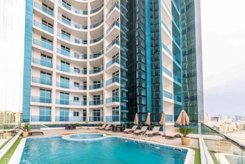 a swimming pool in front of a tall building at Entire -1 Bedroom Apartment In Oasis Tower in Ajman
