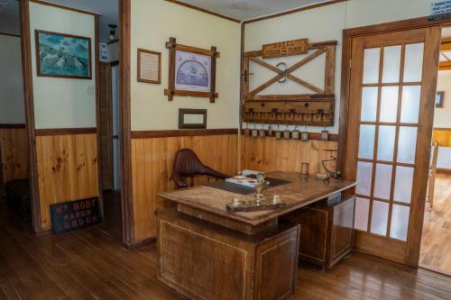 een kamer met een houten bureau in een kamer bij Hotel Boutique 3 Pasos in Cerro Castillo