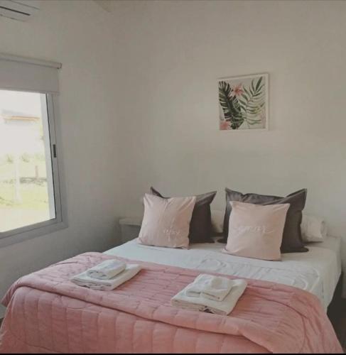 a bedroom with a bed with two towels on it at Complejo El Caldén in Merlo