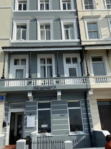 a blue building with a balcony on the side of it at Alexander's in Hastings